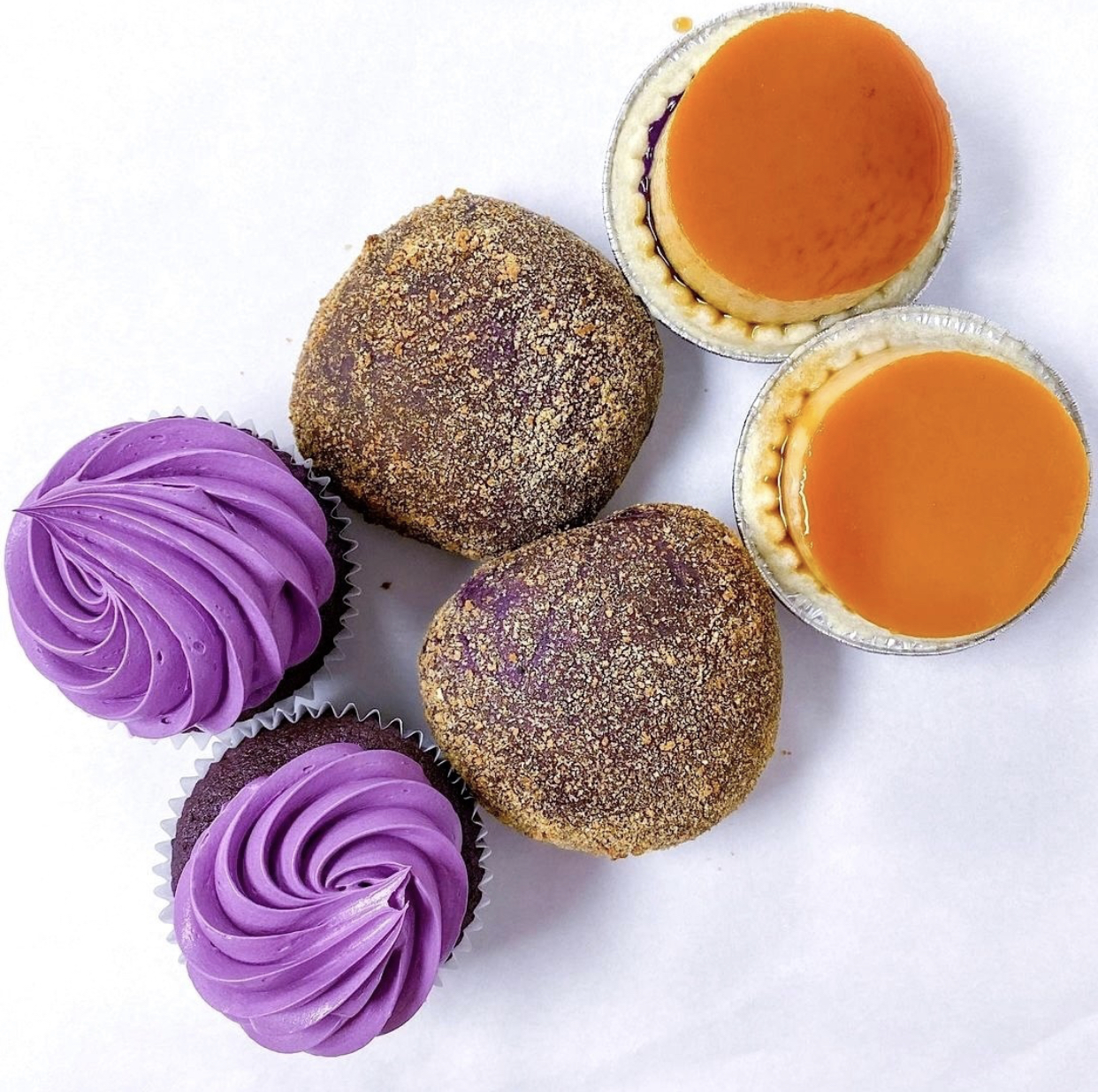 Two ube cupcakes, ube pandesals and ube flan cheesecakes, against a white background.