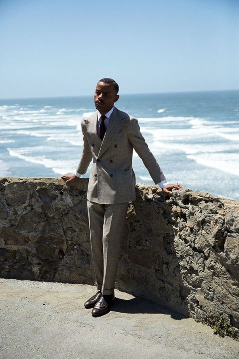 A young Black man stands in front of the Pacific Ocean