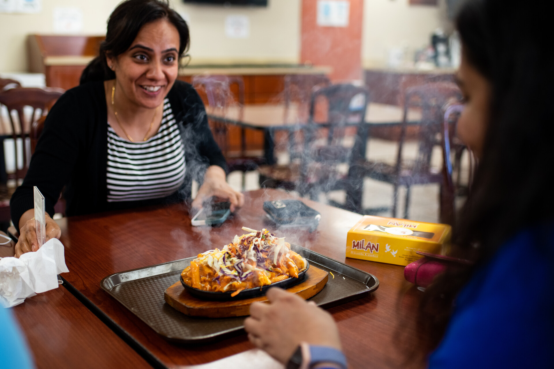 Customers look on with delight as they prepare to eat their samosa sizzler.