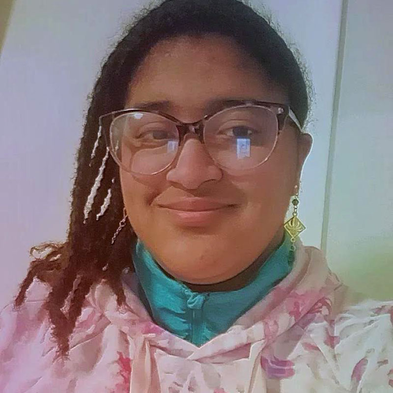 A young Black woman in glasses and braids