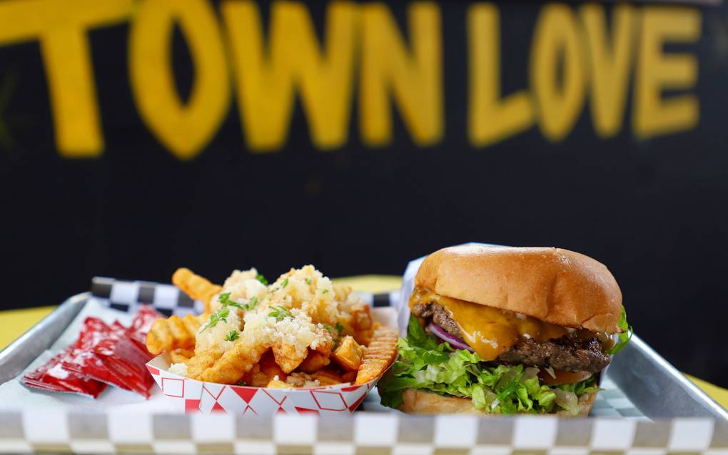 Cheeseburger and garlic crinkle fries on a metal tray; background reads "Town Love."