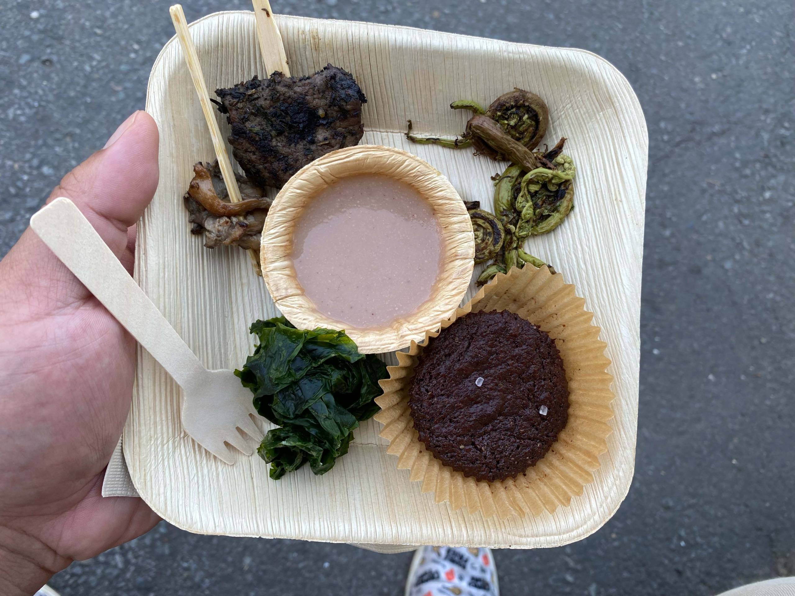 A sampler plate of Ohlone food includes a small dish of acorn soup, fried sea lettuce and a skewer of venison backstrap.