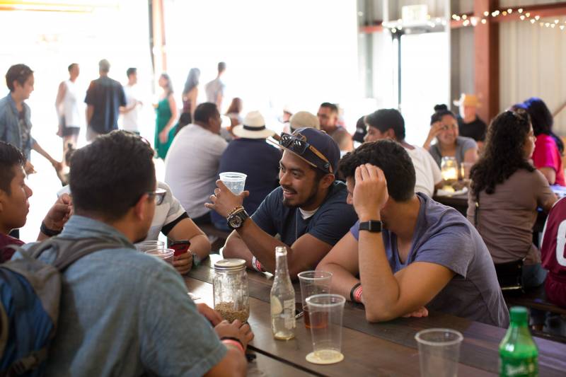A group of men sit and enjoy a beer inside East Brother Beer Company's taproom.