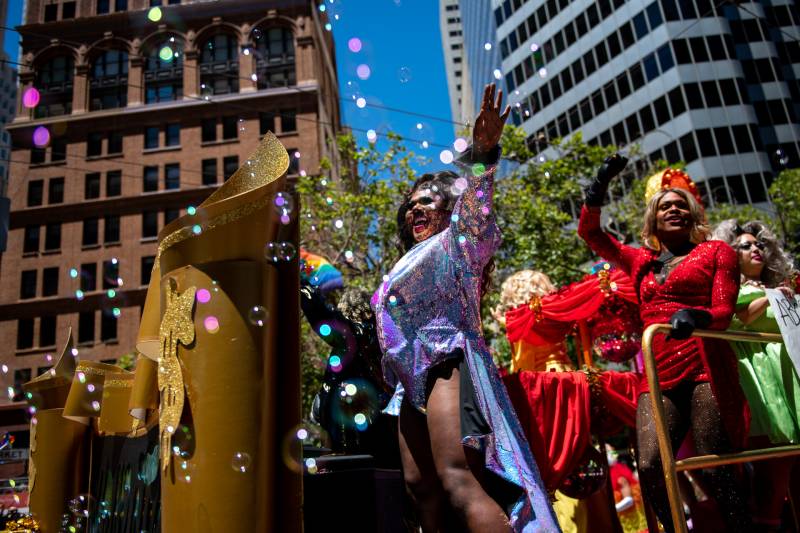 drag queens dressed in colorful costumes on a float in downtown San Francisco