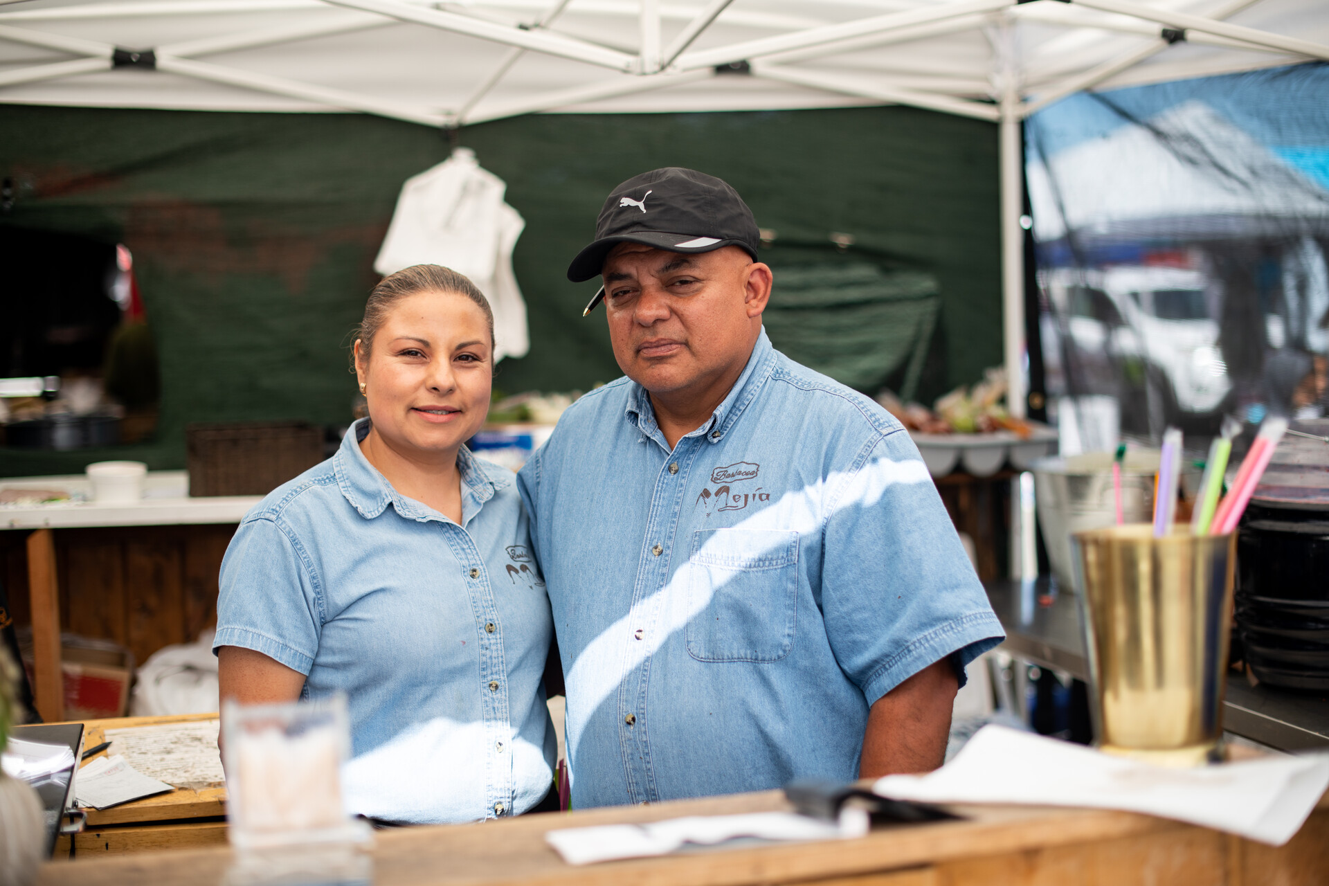 Alondra Montaño and Omar Mejia pose for a portrait in front of their barbacoa stand.