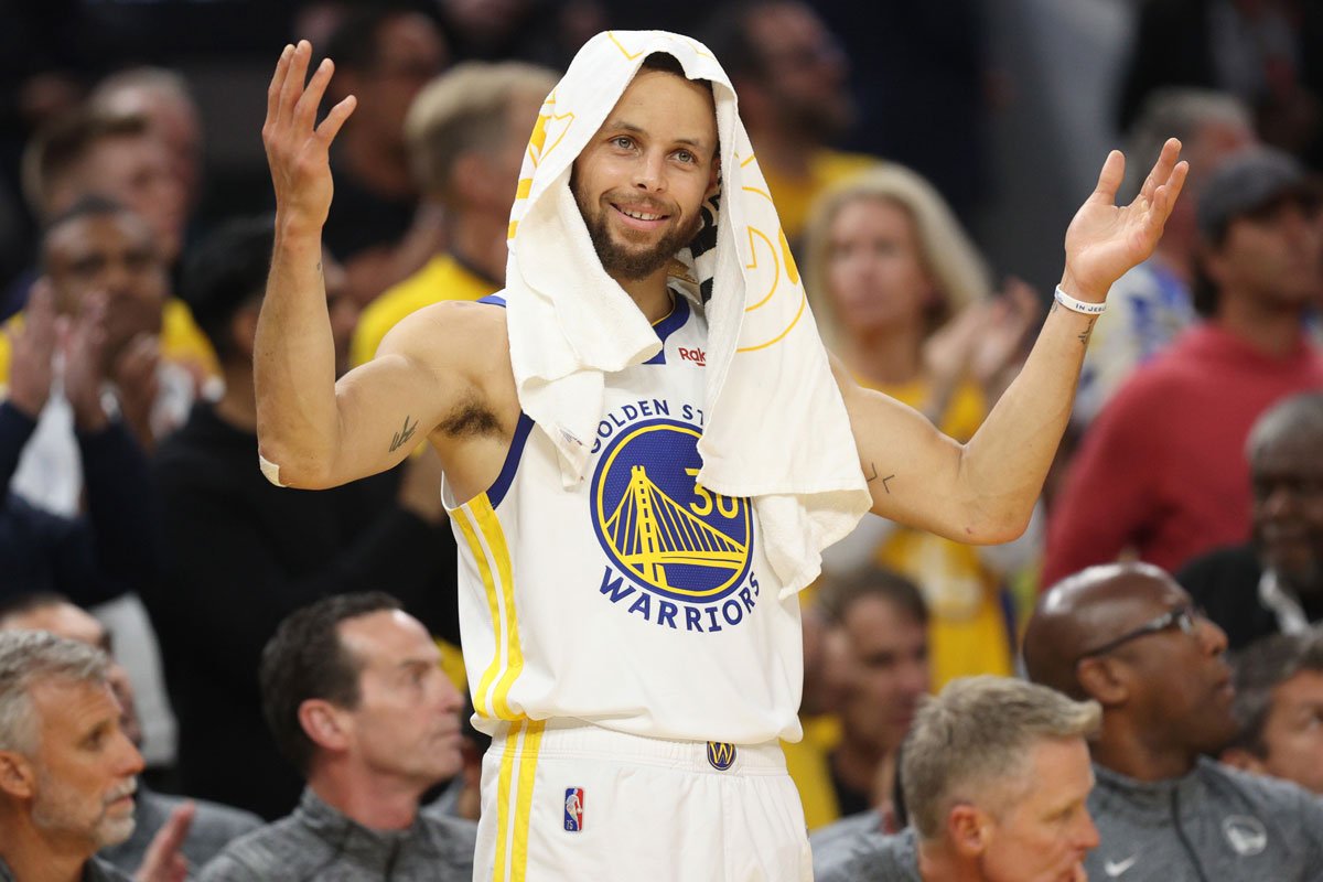 Curry with towel over head and both arms up in "huh?" gesture