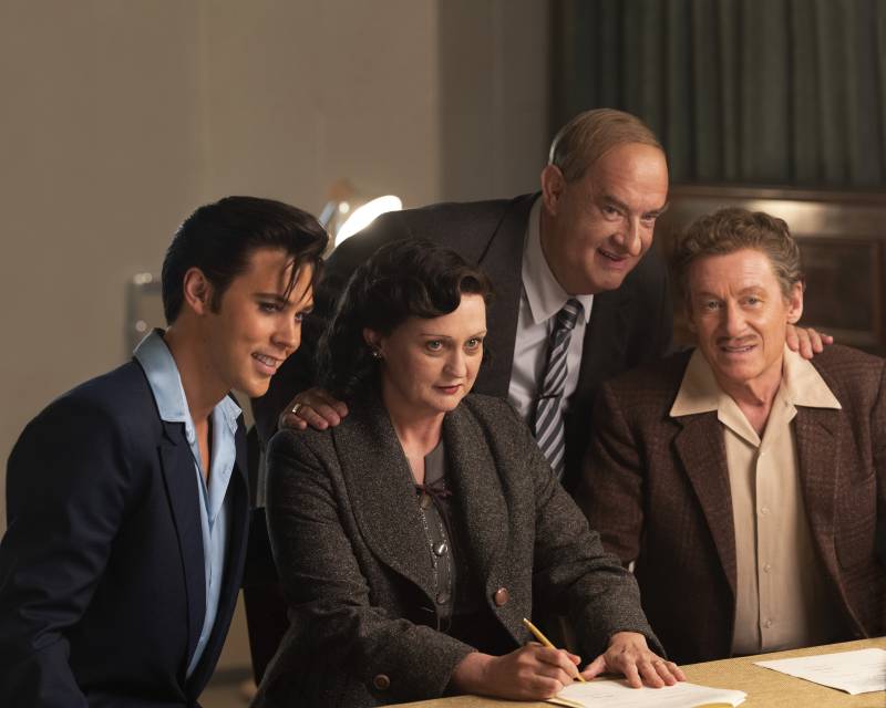 A still from the film 'Elvis,' featuring a woman and three men, including Tom Hanks as Elvis's manager, dressed in 1950s attire.