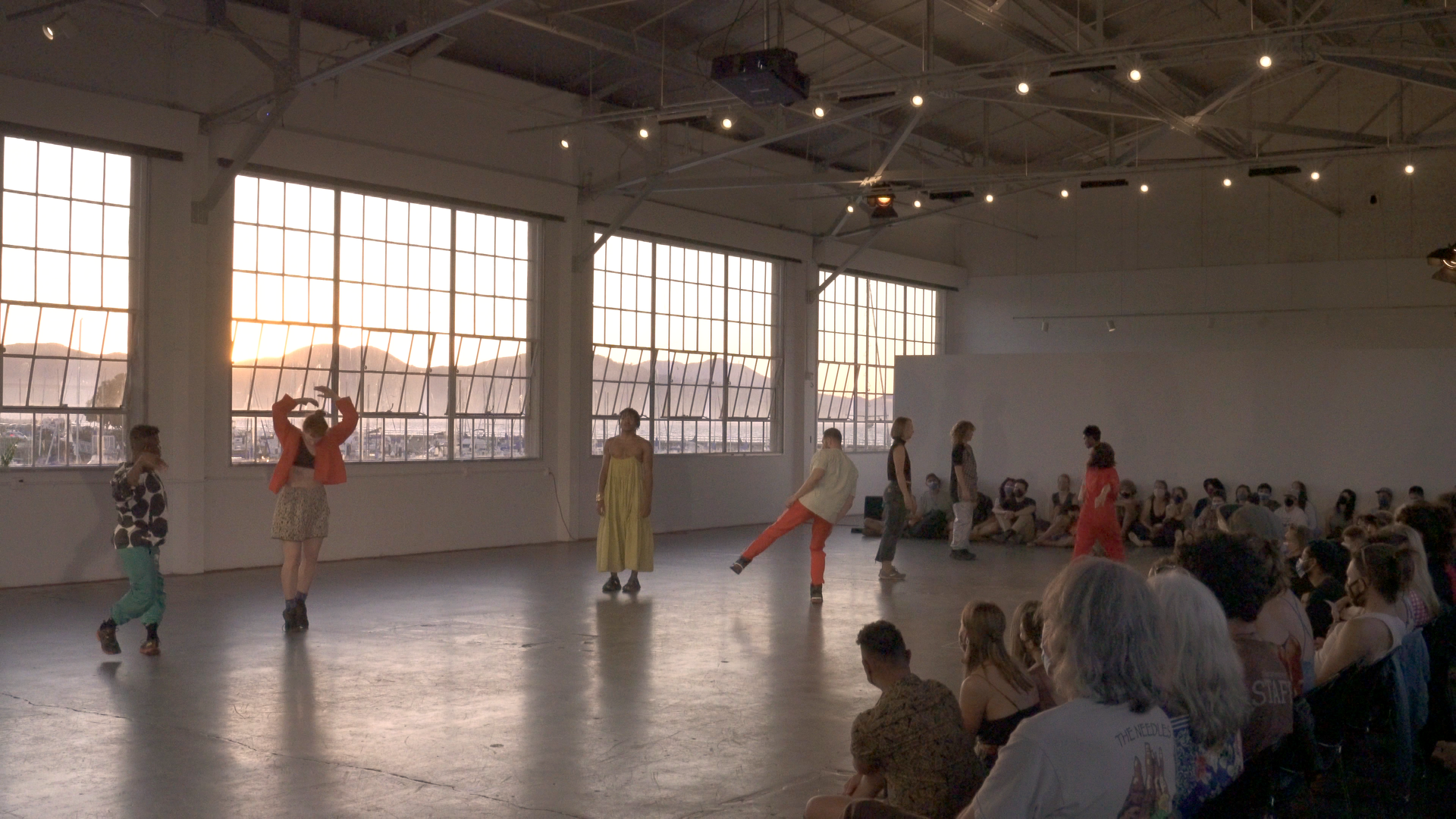 Dancers in gallery space with large open windows