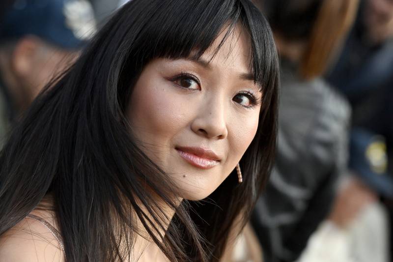 Constance Wu in fresh, dewy make-up turns towards the camera, half-smiling.