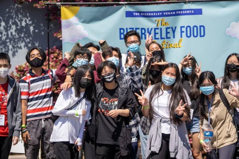 a group of young adults happily standing in front of a banner that says "The Bizerkeley Food Festival"