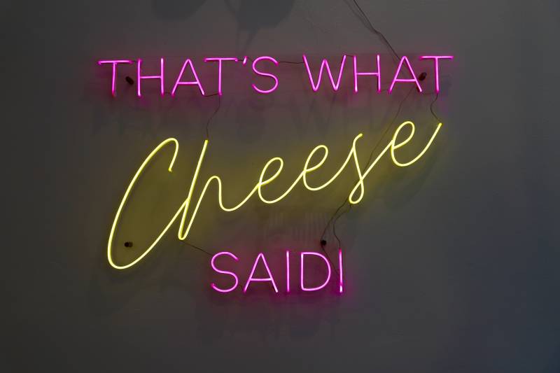 neon signage displayed on the restaurant's wall that reads: "That's what cheese said!"