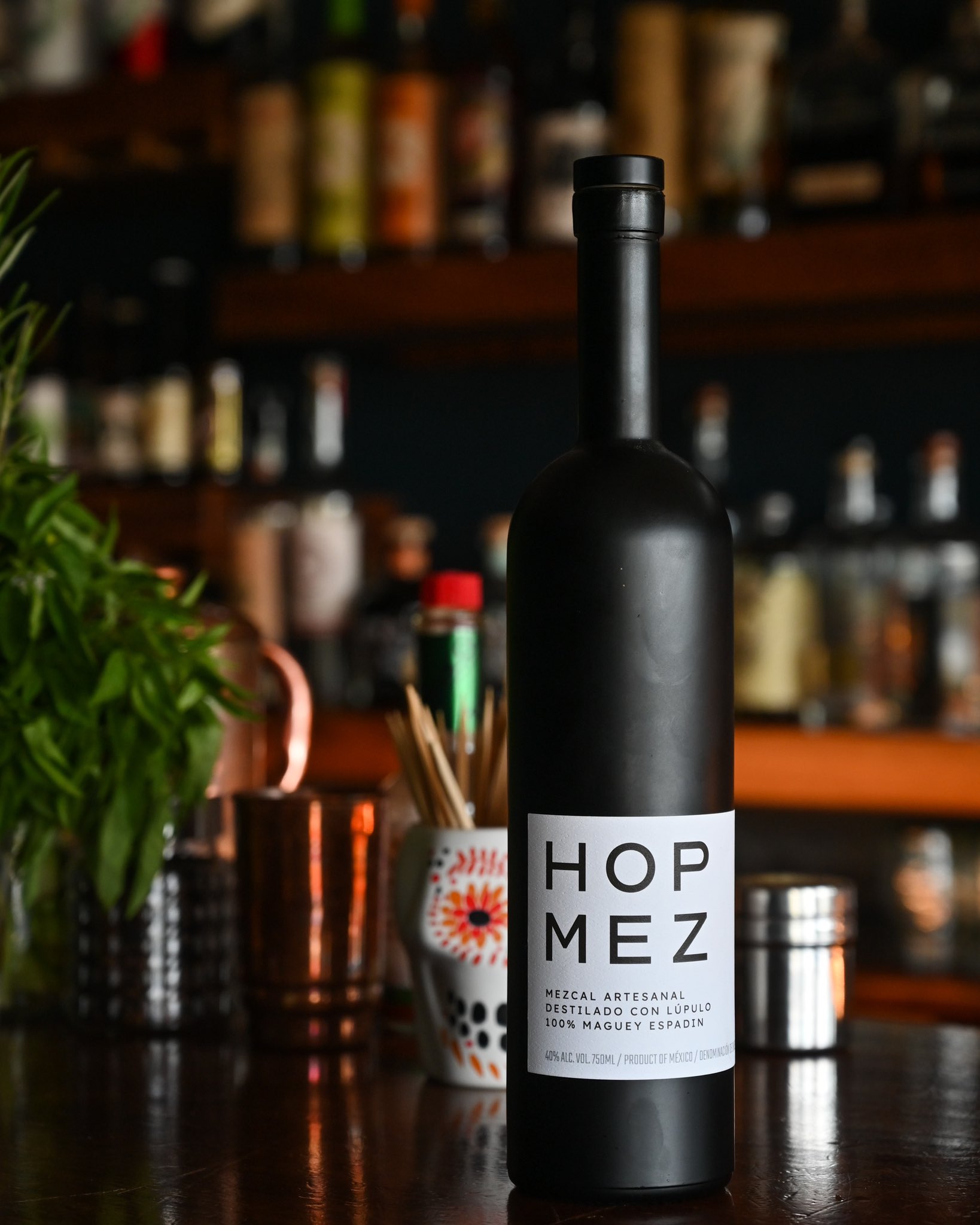 A sleek black liquor bottle with the label "Hop Mez".