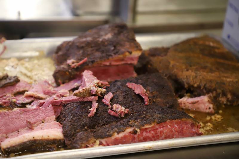 a tray of sliced pastrami in the kitchen of Delirama, waiting to be used for sandwiches, pizzas, and more