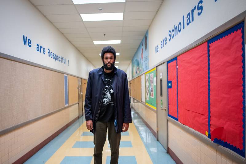 Tongo Eisen-Martin stands in the hallway of Parker Elementary School in East Oakland.