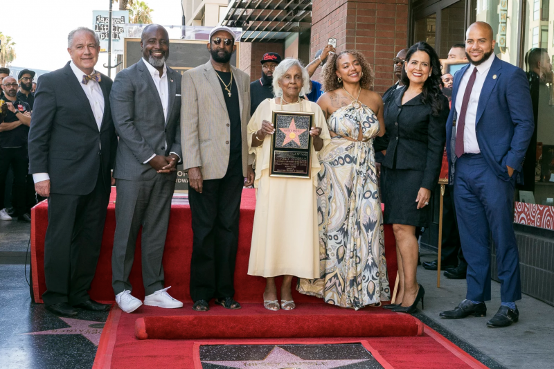 Four men and three women line up on a red carpet behind a Hollywood Walk of Fame star with Nipsey Hussle's name on it.