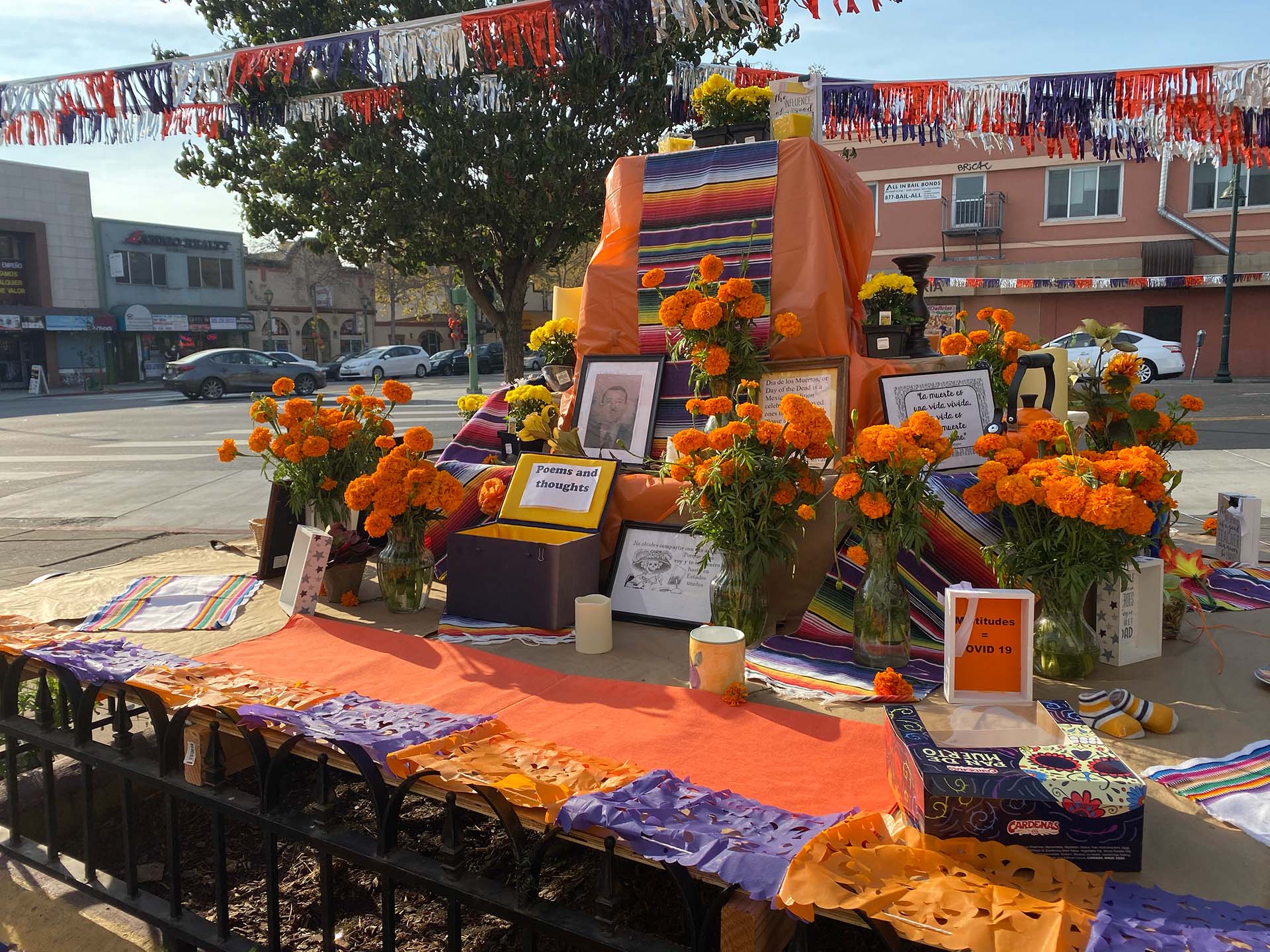 A marigold-covered altar for Día de los Muertos on a street corner in Fruitvale.