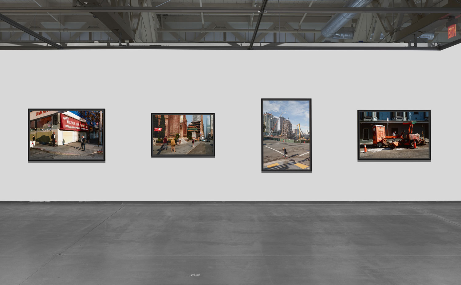 Four framed color photographs of SF street life on white wall