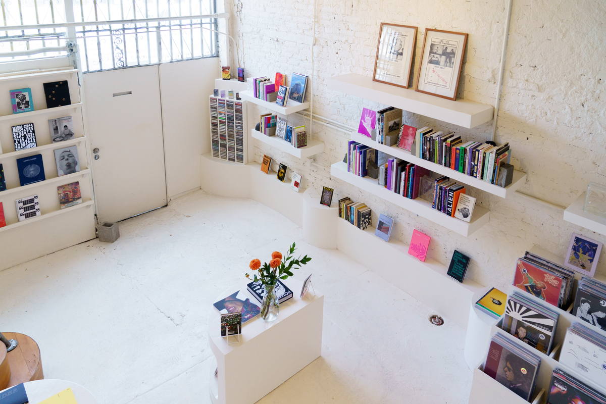 Colorful books and records in a white wallled and floored space 
