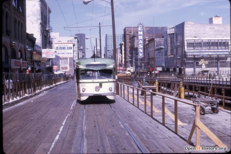 A street car runs up Market St on top of a temporary wooden roadway. Construction is visible on one half of the street.
