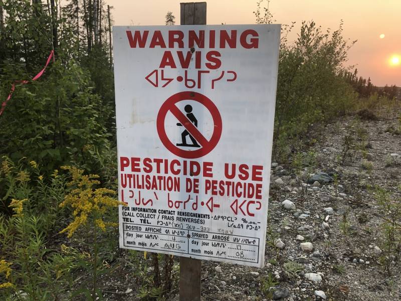 a sign reads 'warning, pesticide use'