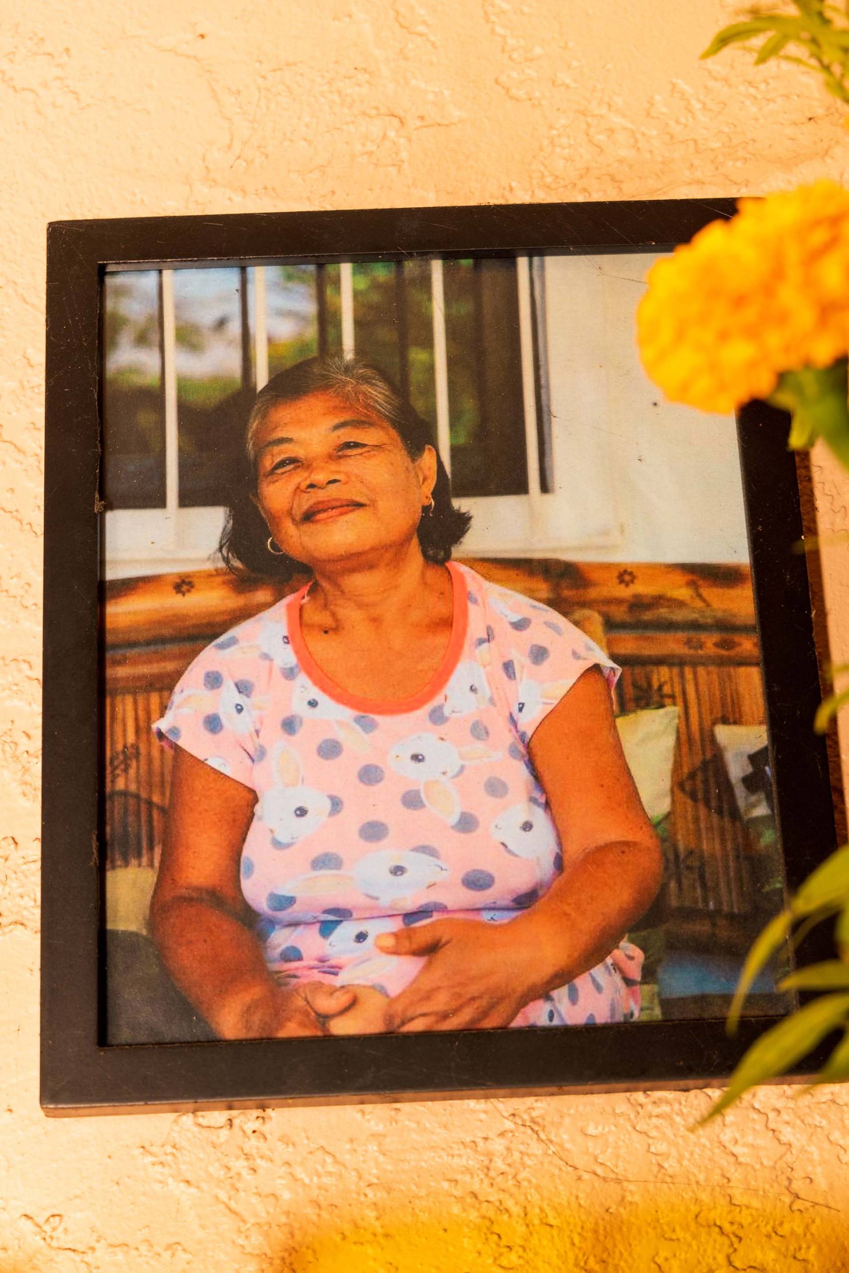 A framed photo of an older Filipino woman in a polka dotted blouse.