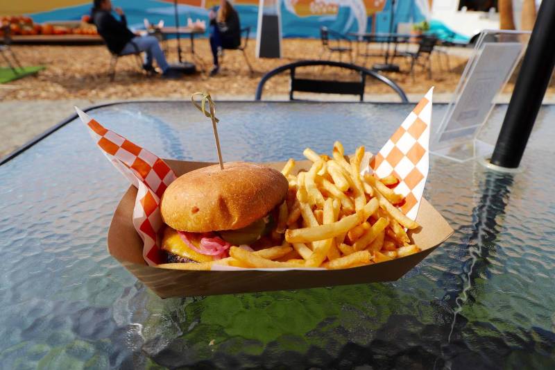 a burger and order of fries on a paper tray on a table at an outdoor eatery in Richmond