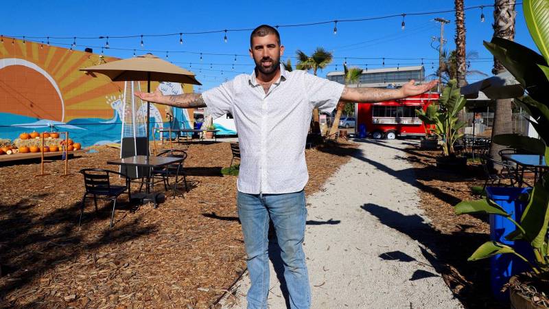 food entrepreneur, Emmet Kauffman, stands in the outdoor patio of his new restaurant, The Backyard, which is located in a lot behind a hardware store