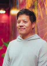 Headshot of an Asian man in a hoodie.