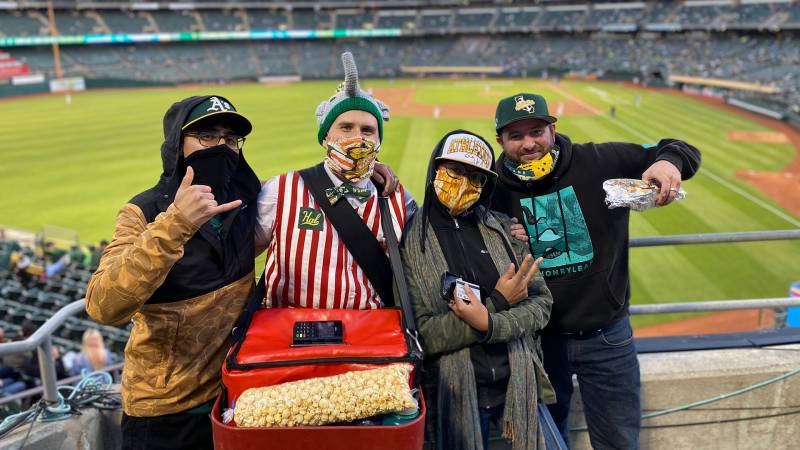 A's fans standing with hot dog vendor, Hal Gordon, at the Oakland Coliseum