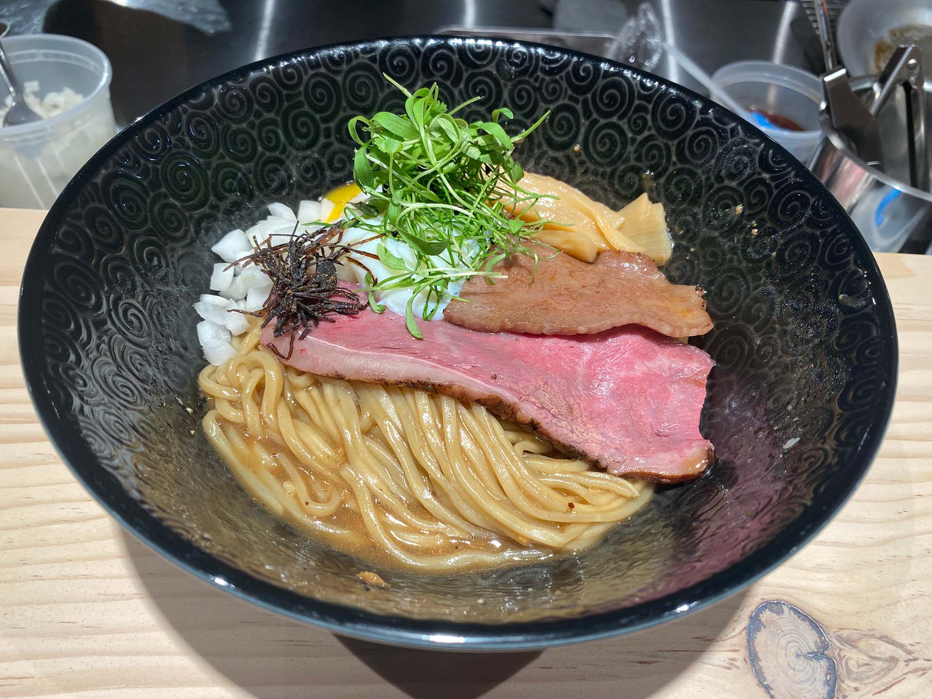 A bowl of ramen with no soup, topped with a slice of wagyu beef.