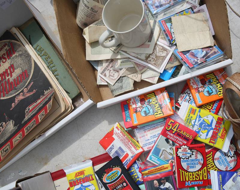 a pile of baseball cards and money among other antique on a table
