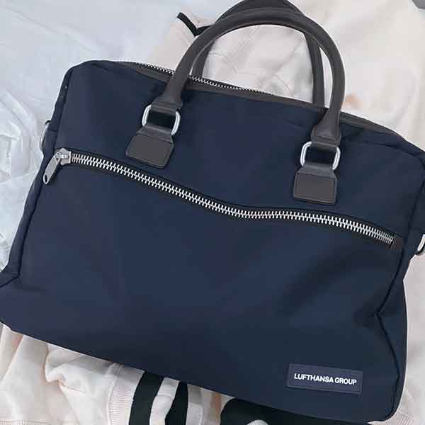 a blue handbag, sitting against a white linen background