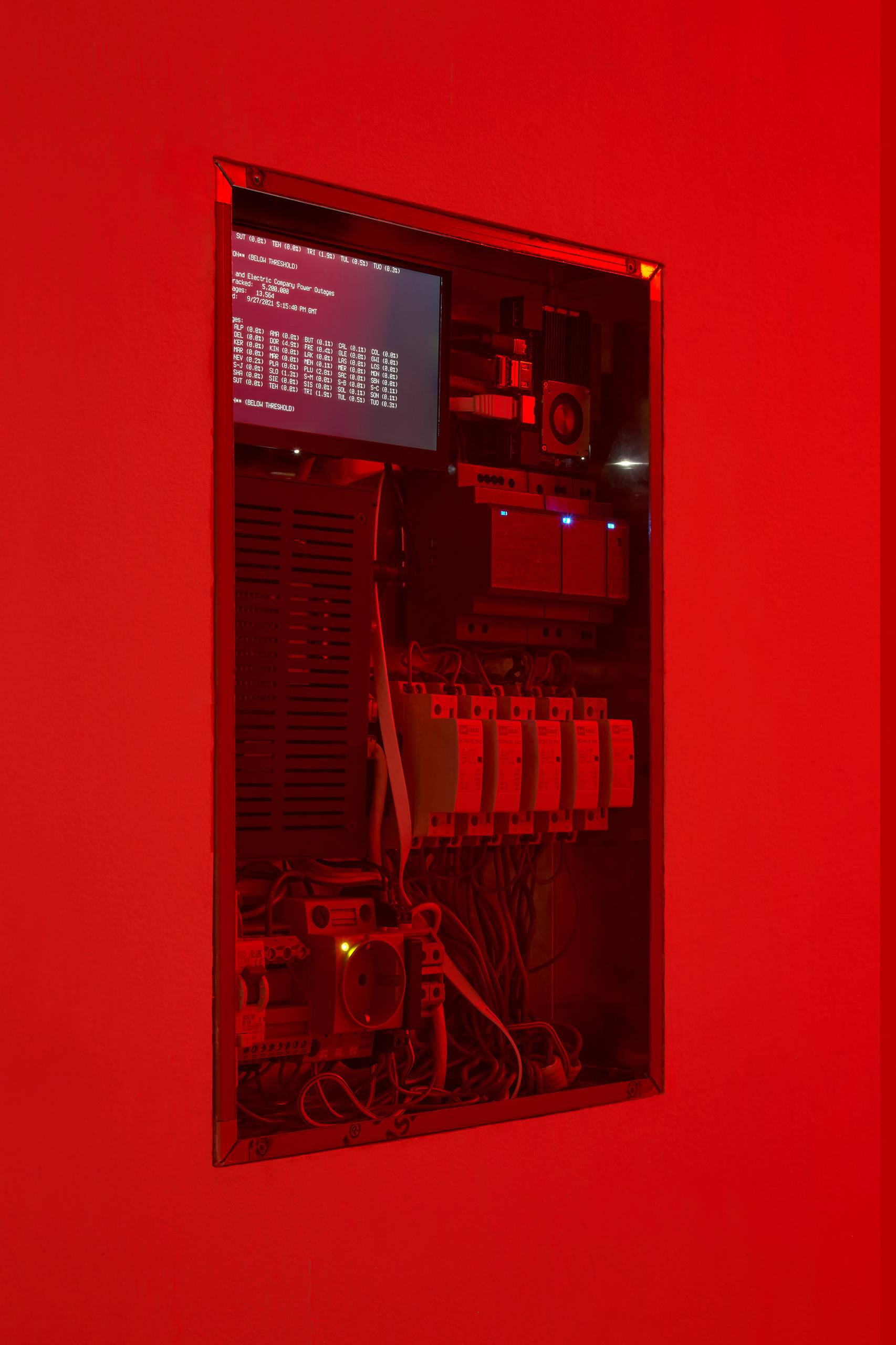Red-tinged image of electrical box with data readings on screen