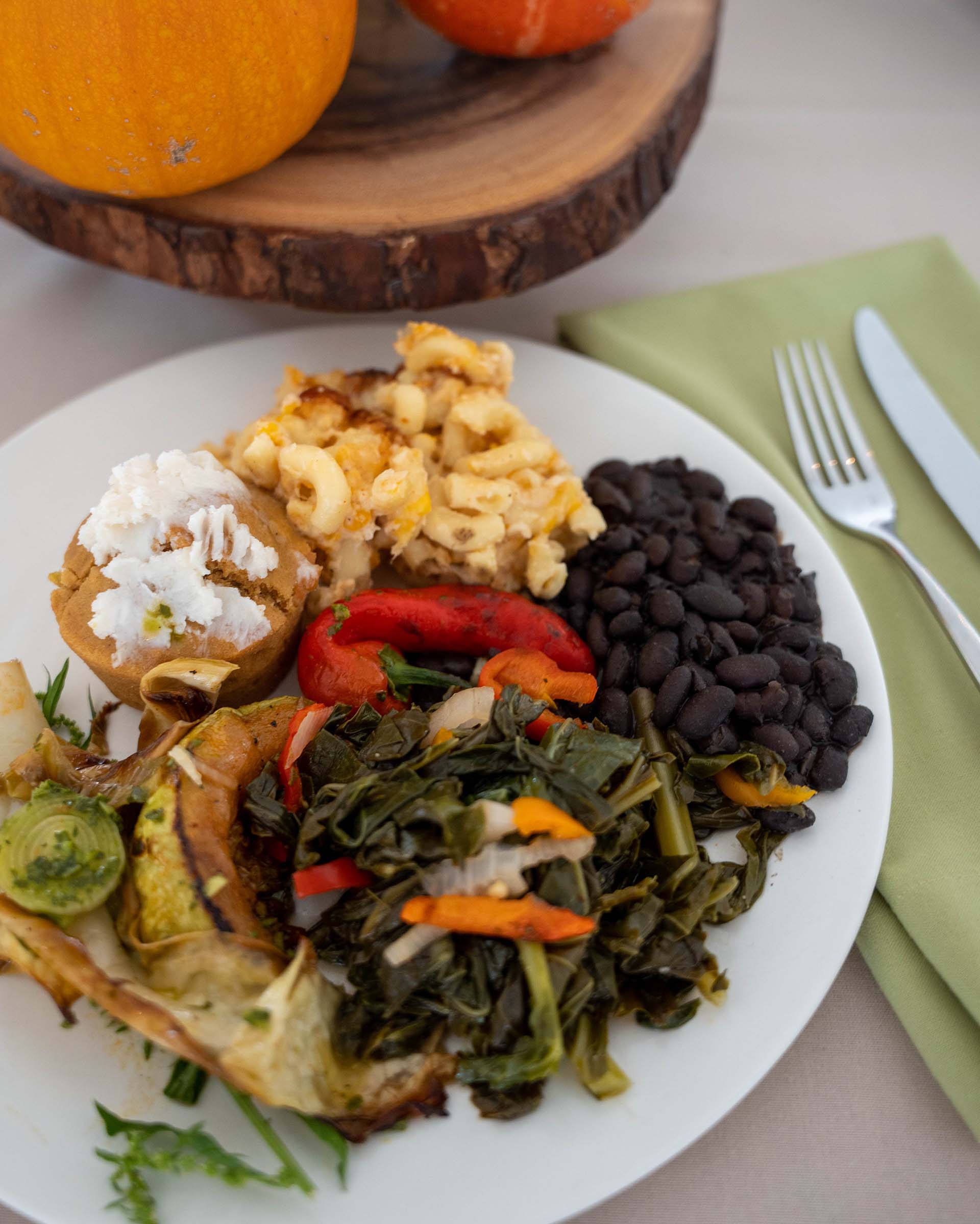 An abundant plate of food, including greens, beans and mac and cheese.