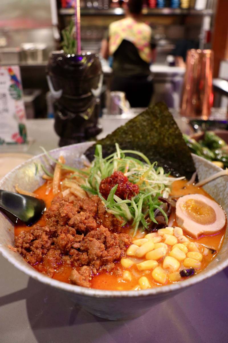 a bowl of spicy miso ramen, with spicy ground pork, egg, corn and more