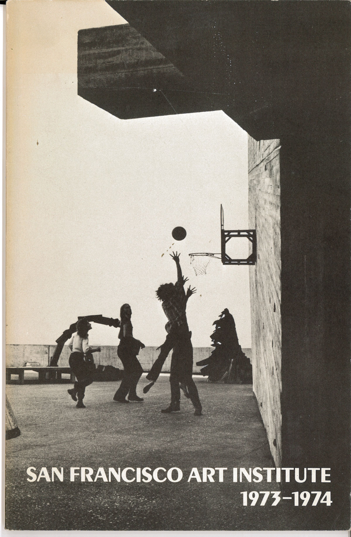 Booklet cover with text over black and white photograph of students playing basketball on brutalist campus