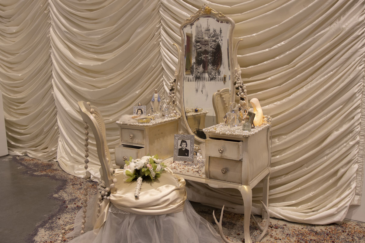 White chair in front of vanity with white fabric draped behind