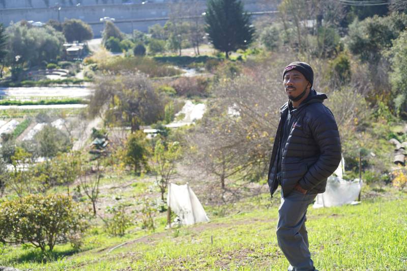 Christopher Renfro standing on a hill overlooking San Francisco's Alemany Farm.