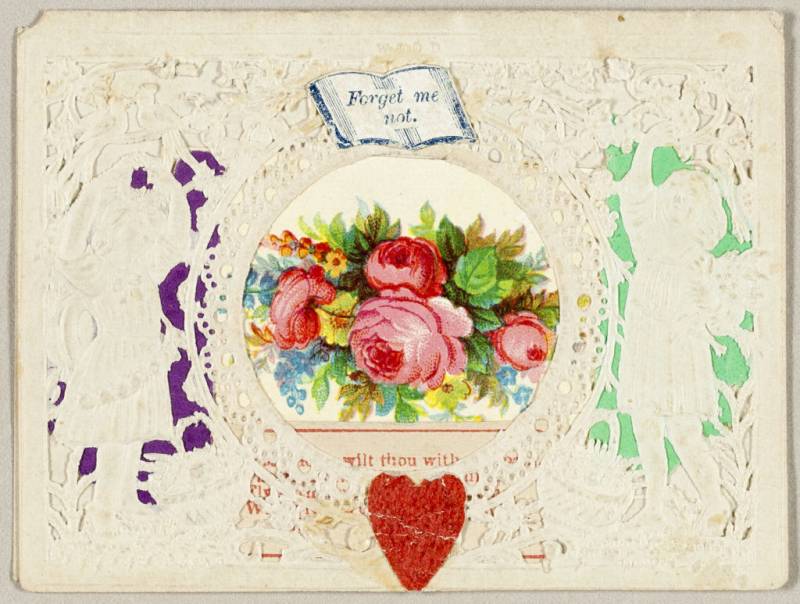 An image of pink roses and foliage surrounded by ornate paper cutouts, with a heart underneath and the illustration of an open book reading ‘Forget Me Not.’