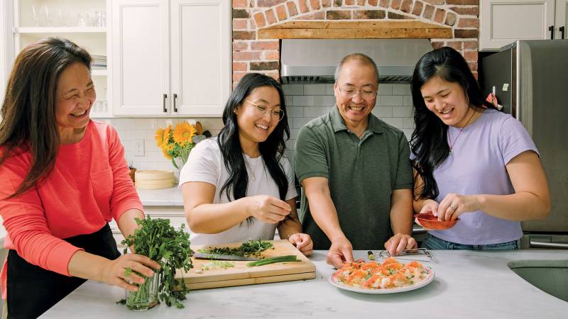 A Chinese American family prepares a shrimp dish on their kitchen counter.