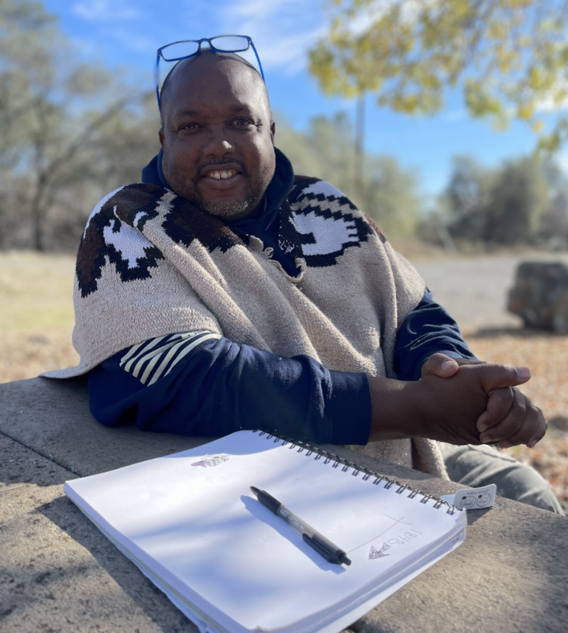 Michael Harris, historian and chair of Friends of Negro Bar, sits at a park bench at the site of a forthcoming community center for the park. 