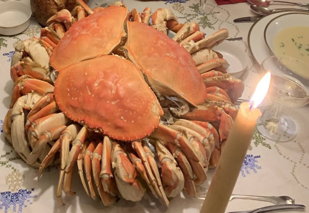 Three cooked Dungeness crabs in their shell, arranged to form the shape of a blossoming flower.