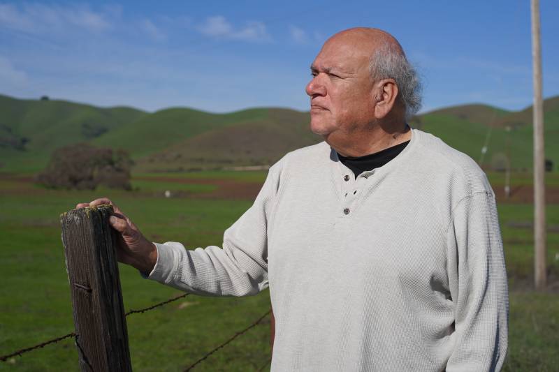 Valentin Lopez, tribal chair leader of the Amah Mutsun tribal ban, standing near the fence that separates the road from the historic sacred site known as Juristac in Santa Clara County.