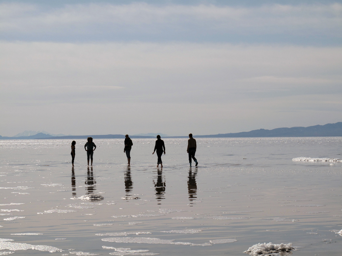 Five figures in a watery plain, sky and ground both gray blue