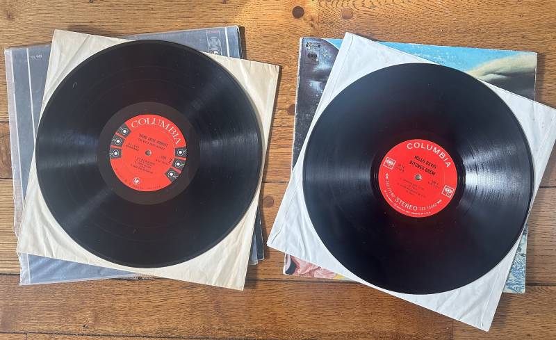 two vinyl records from Columbia, with red labels, seen out of their sleeves