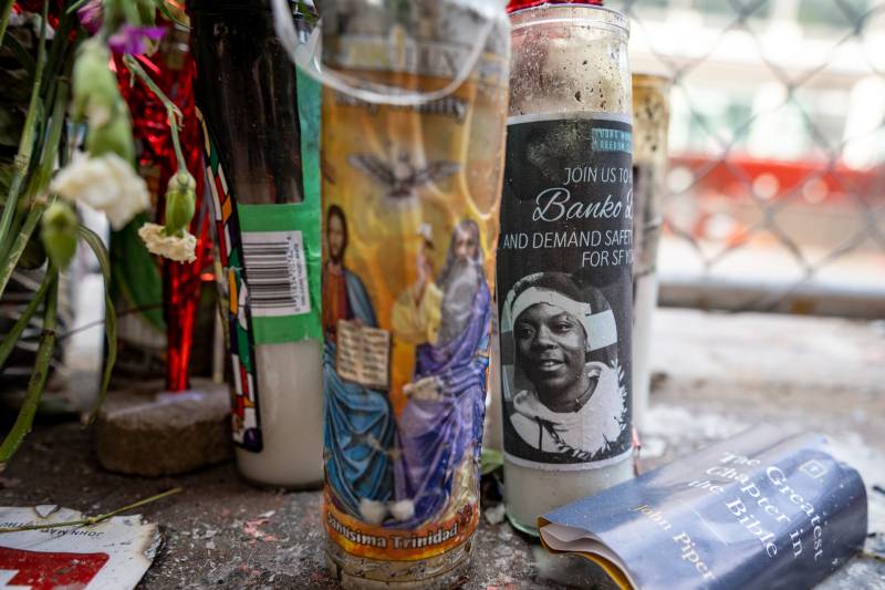 Candles on the sidewalk feature a portrait of Banko Brown, a 24-year-old Black trans man.