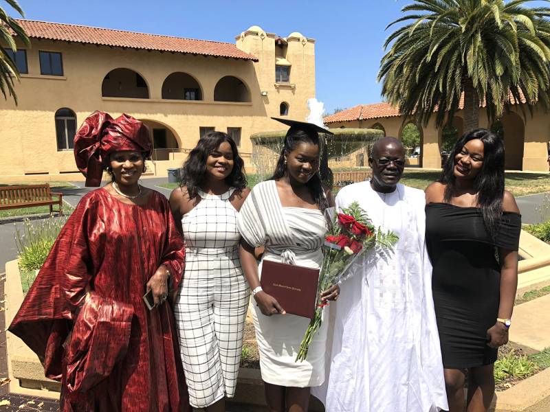 a group of five people, a family from Senegal, pose at a graduation ceremony from Stanford