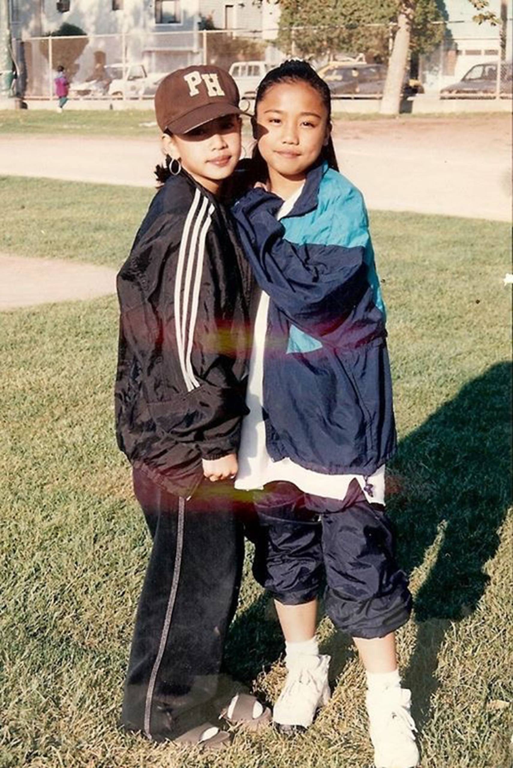 Two middle school age Filipino American girls dressed in athletic warm-ups, in a throwback photo from the 1990s.
