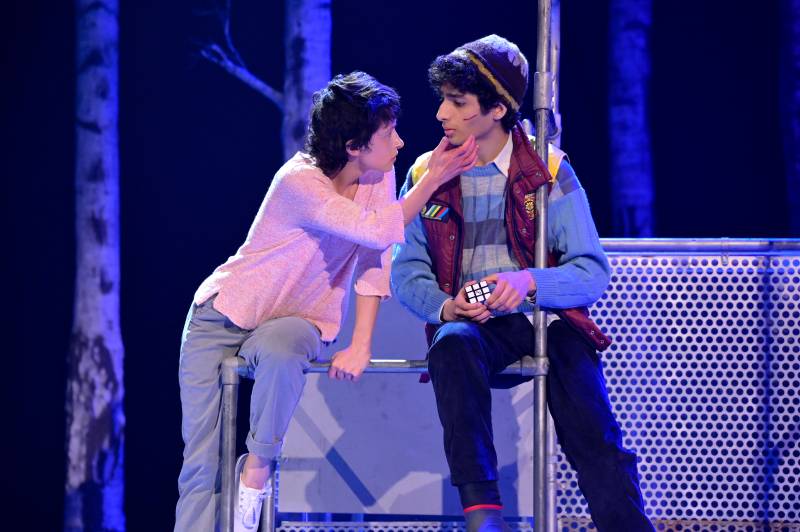 two young people with dark hair on stage in a play