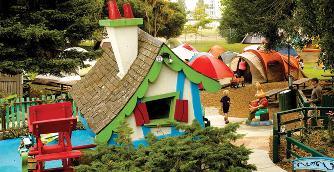 tents are seen set up next to a storybook structure in a children's amusement park